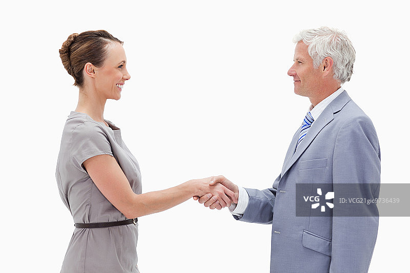 商人与一名女子面对面握手，背景是白人图片素材