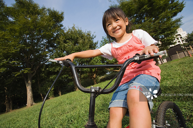 女孩在公园里骑自行车图片素材