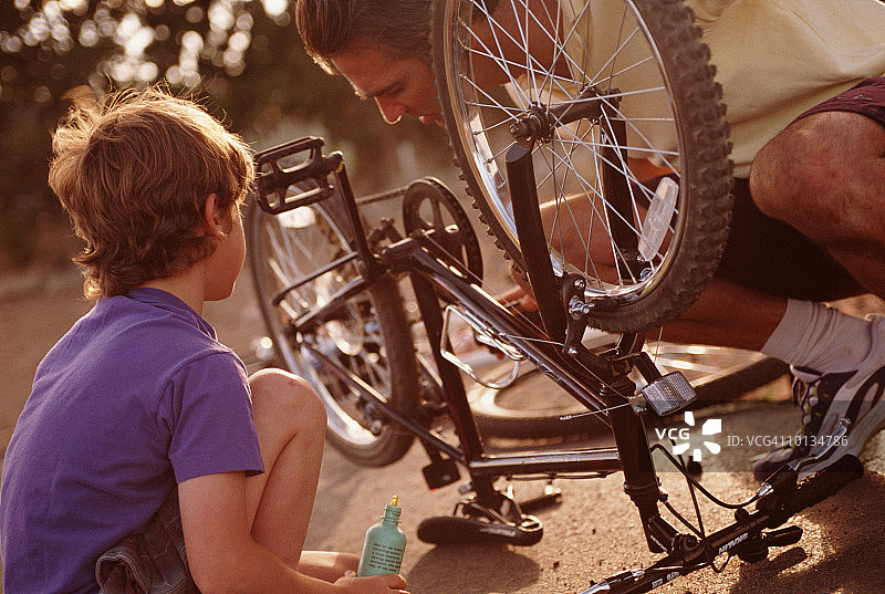 一对父子在新墨西哥州的圣达菲修自行车图片素材