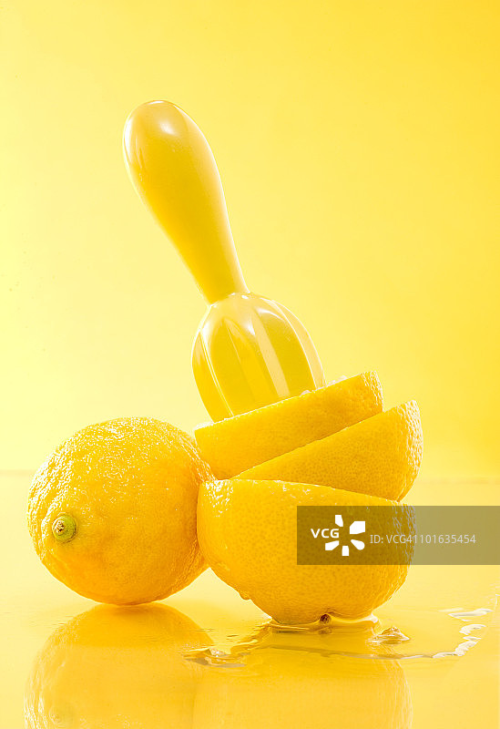 挤柠檬在黄色的背景图片素材