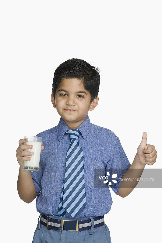 一个男生拿着一杯牛奶，打着竖起大拇指的手势图片素材