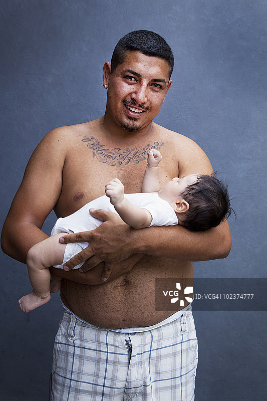 年轻的父亲抱着他的孩子图片素材