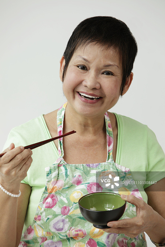 拿着筷子和碗的成熟中国女人图片素材