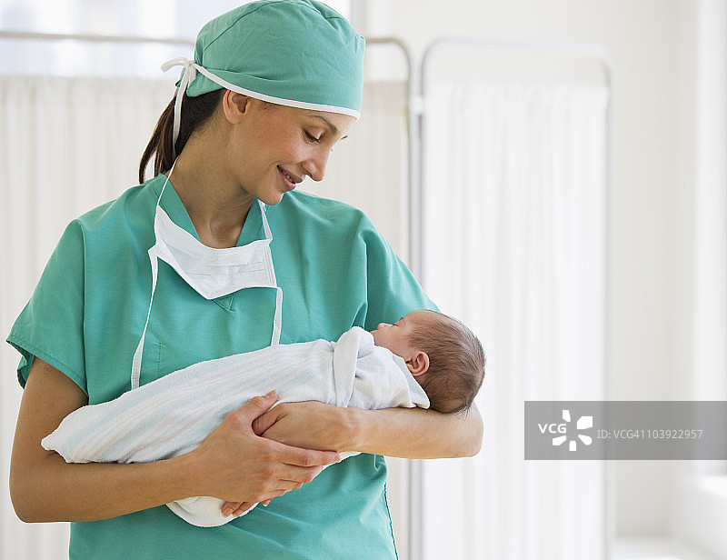 护士抱着襁褓中的婴儿图片素材