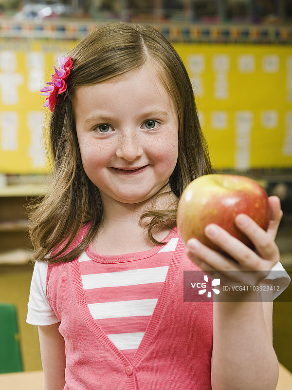 幼儿园学生在教室里拿着苹果图片素材