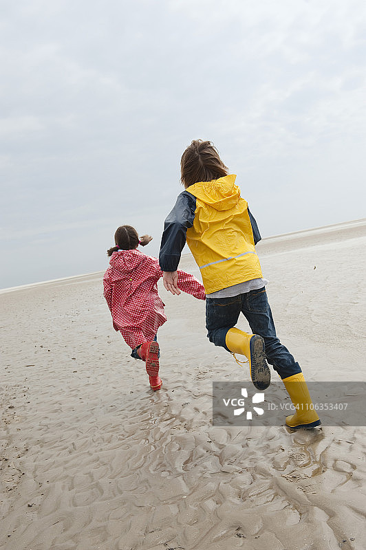 德国，圣彼得-奥尔丁，北海，孩子们(6-9岁)在海滩上跑步图片素材