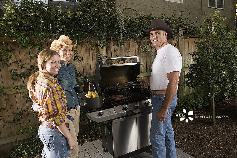一个家庭站在烧烤架旁边的肖像图片素材