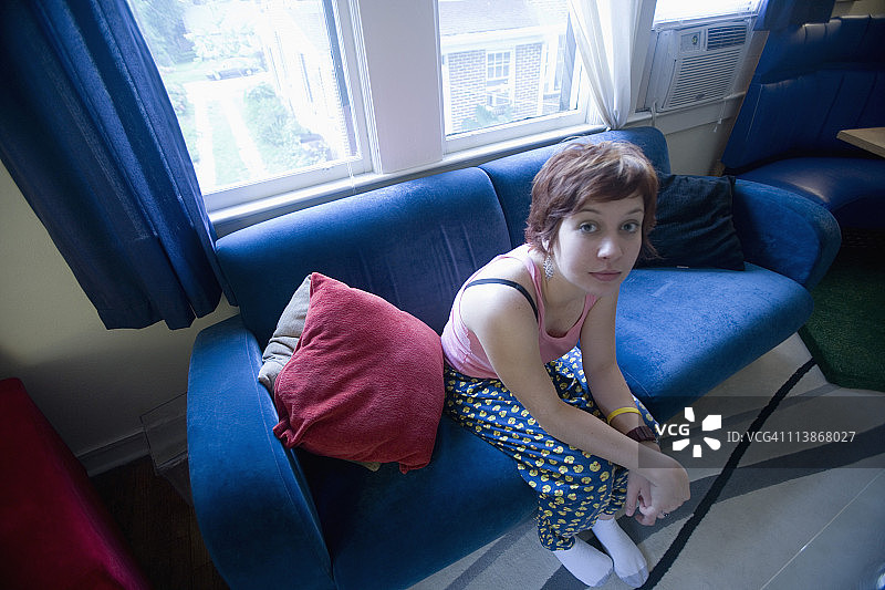 一个穿着睡衣坐在沙发上的年轻女人的肖像图片素材