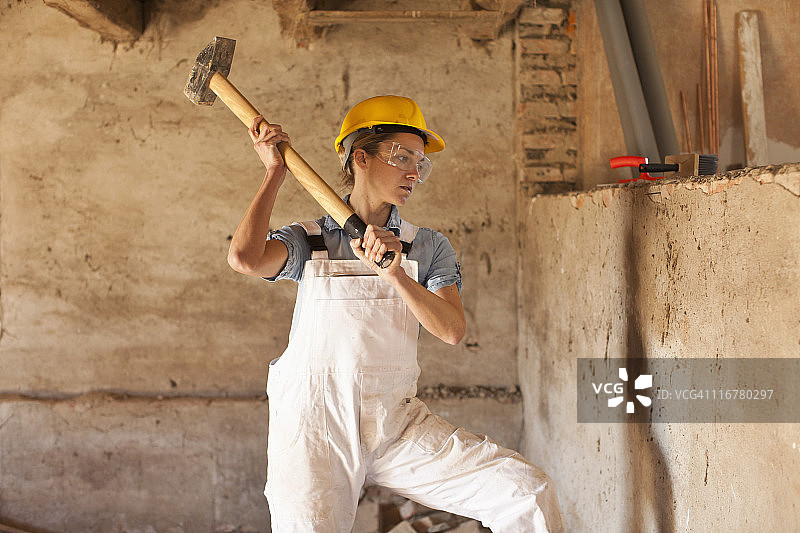 一个挥舞着大锤的女建筑工人图片素材