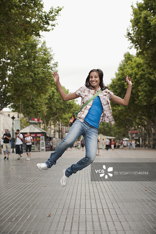 女人在城市里跳跃的肖像图片素材