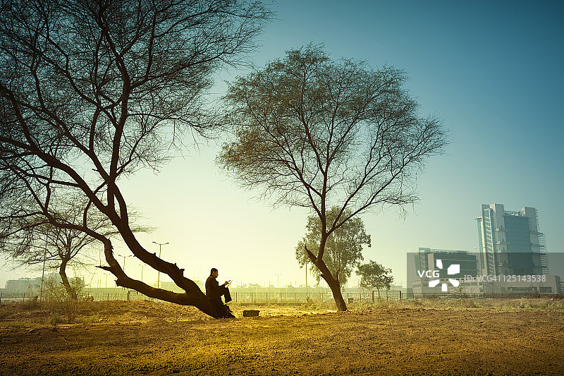 在乡村景观商人坐在远离城市的树下图片素材