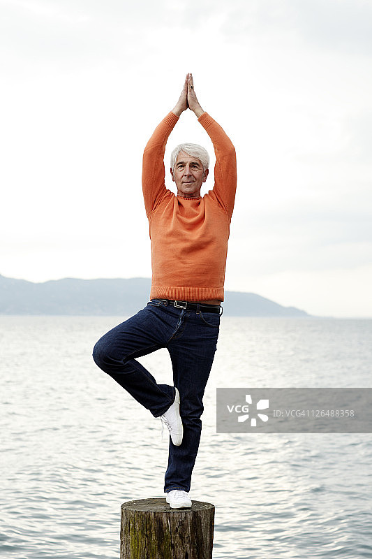 意大利，在水边练习瑜伽的老人图片素材
