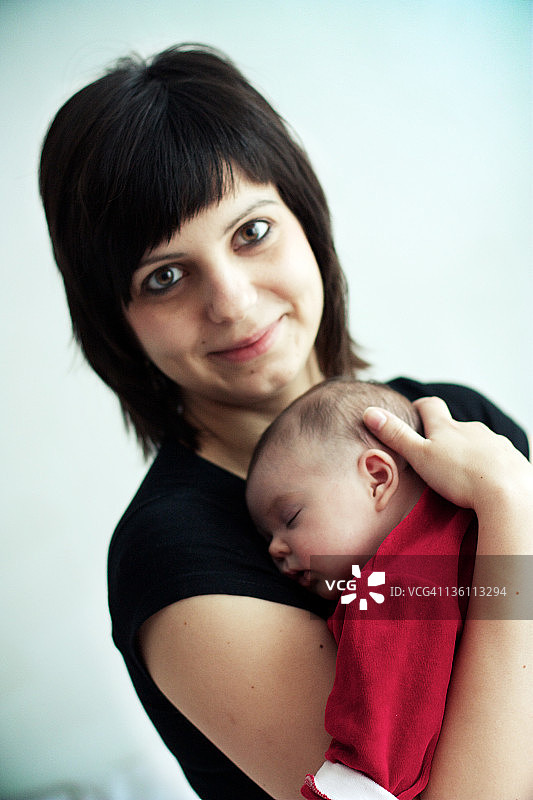 母亲抱着熟睡的婴儿的肖像图片素材