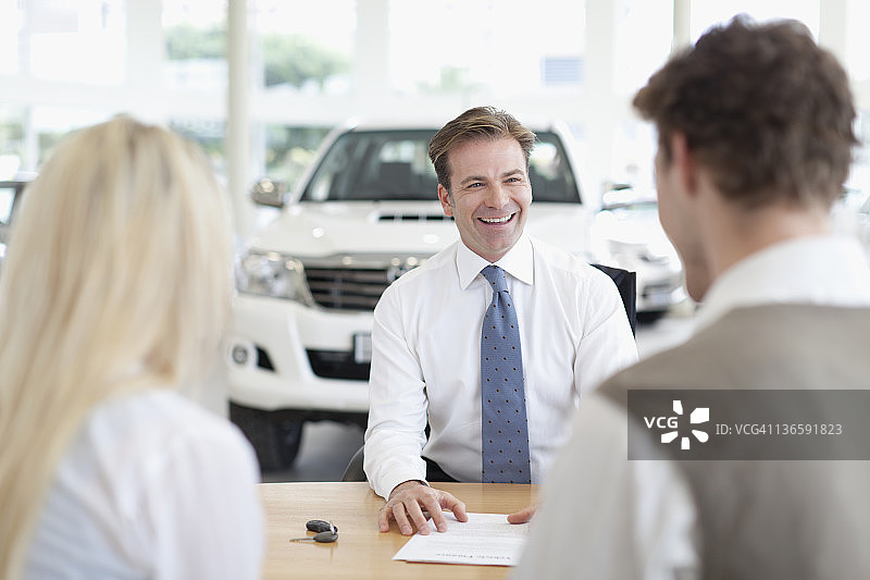 汽车销售员和客户在桌子前图片素材