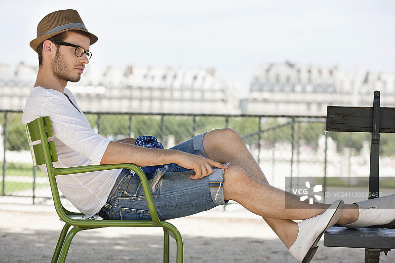 法国巴黎杜伊勒里宫花园，一名男子坐在椅子上休息图片素材