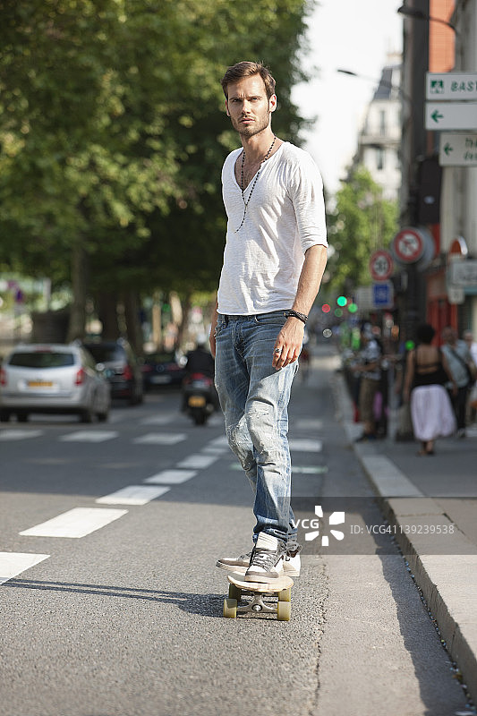 法国巴黎，一名男子在路上玩滑板图片素材
