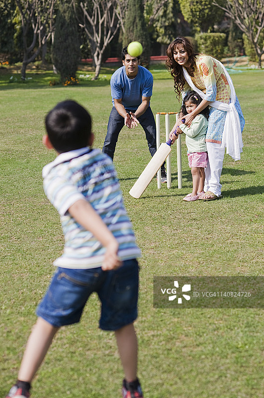 印度哈里亚纳邦古尔冈，一家人在草坪上打板球图片素材