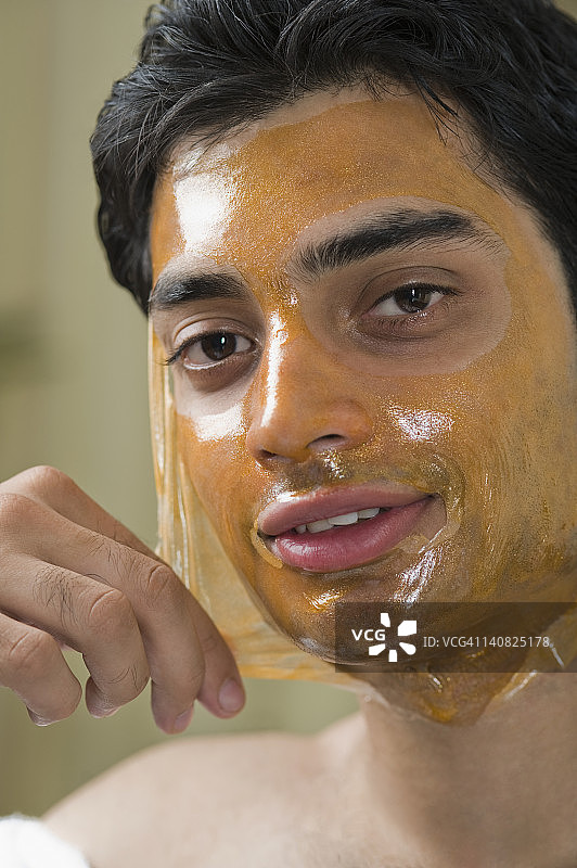 一个男人从脸上撕下面具的肖像图片素材