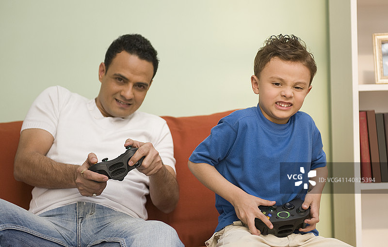 男人和他的儿子在玩电子游戏图片素材