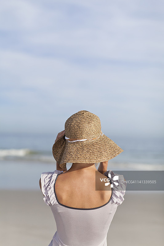 海滩上戴草帽的女子图片素材