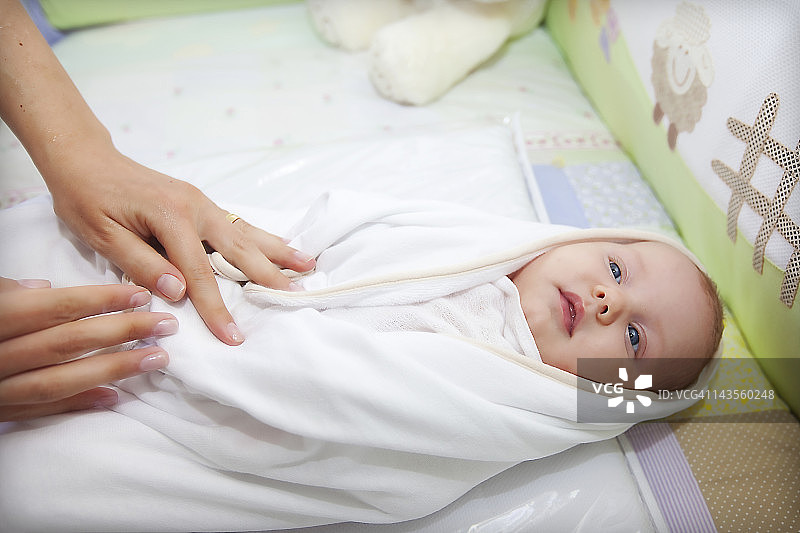 沐浴后用毛巾包裹婴儿图片素材