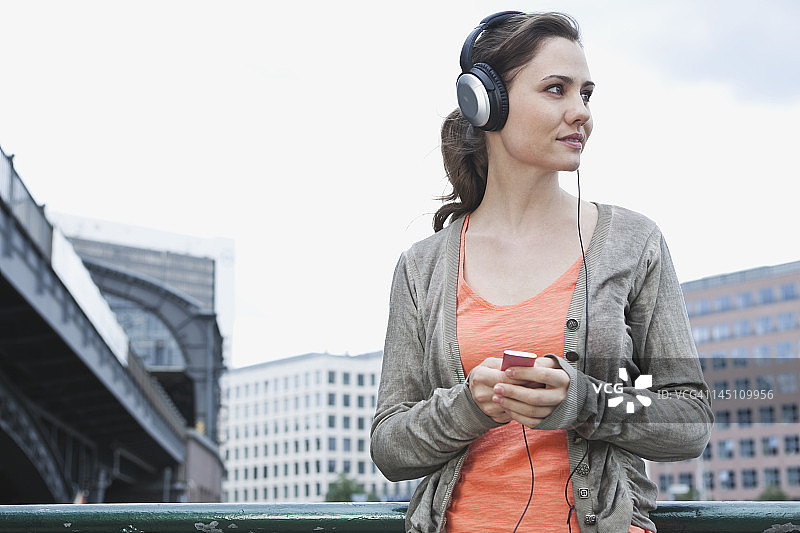 德国，柏林，一名女子戴着耳机听音乐图片素材