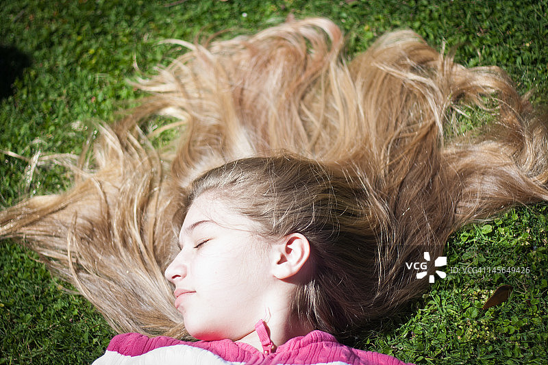年轻女孩躺在草地上图片素材