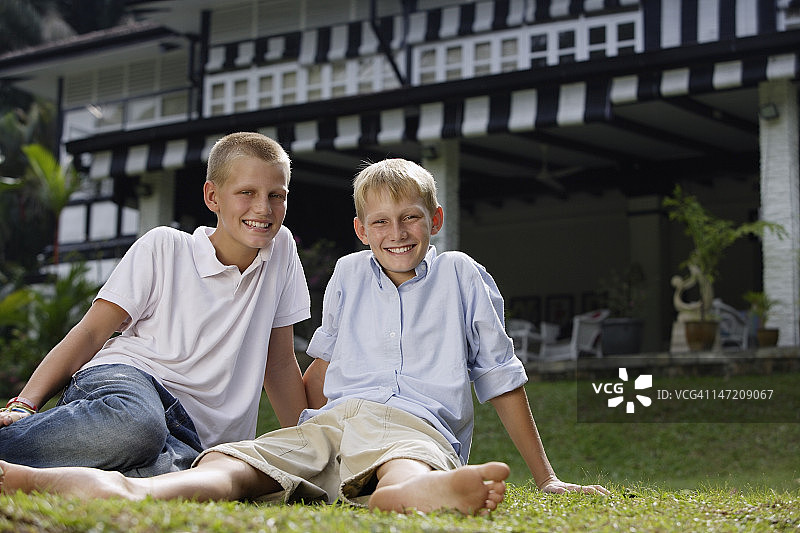 两个男孩坐在草地上图片素材