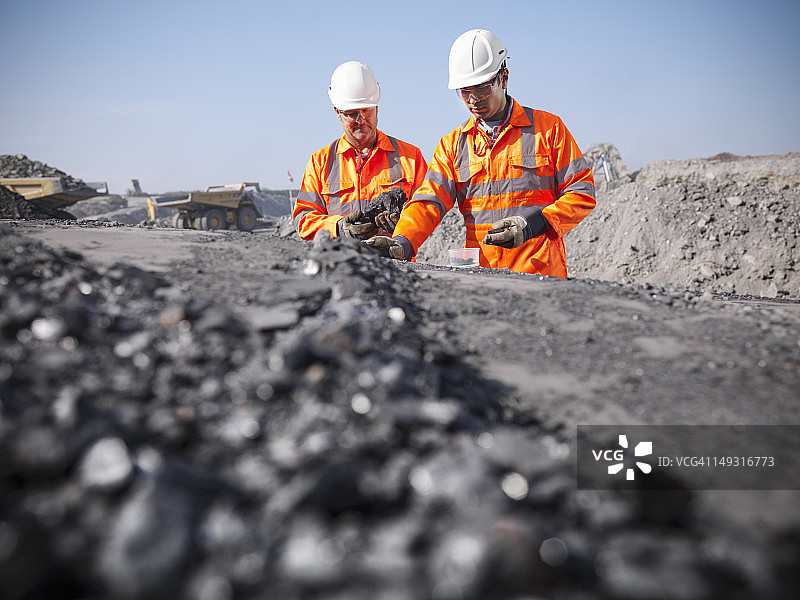 煤矿工人在露天矿井中检查煤炭图片素材
