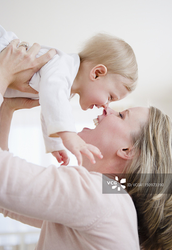 美国，新泽西州，泽西城，母亲举起儿子(6-11个月)图片素材