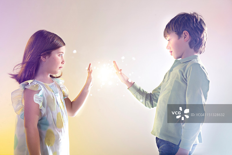 女孩和男孩触摸明亮的灯光图片素材