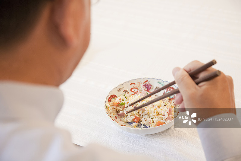 亚洲男人用筷子吃饭图片素材
