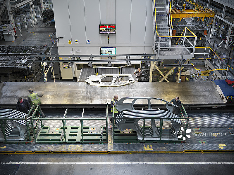 高角度的观点，工人处理汽车零件，因为他们出来的汽车工厂图片素材