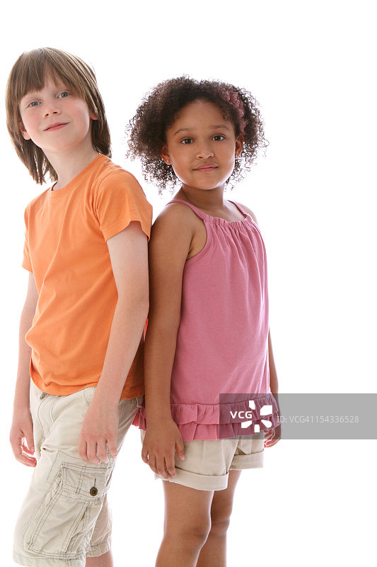 男孩(8-9)和女孩(6-7)站在一起互相看着图片素材