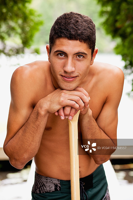少年，倚着独木舟的桨，肖像图片素材