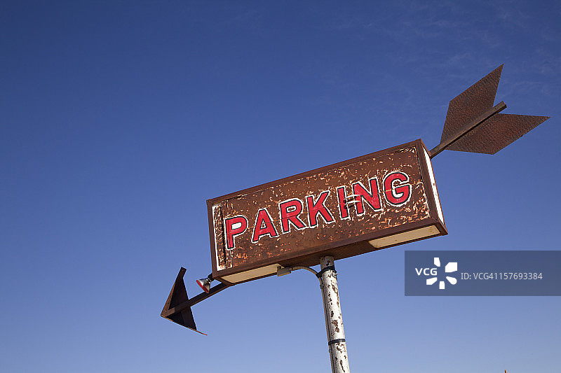 生锈的停车标志与箭头对抗晴朗的沙漠天空图片素材