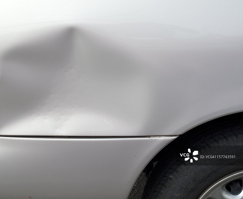 特写的一个凹痕在一个灰色的汽车外部图片素材