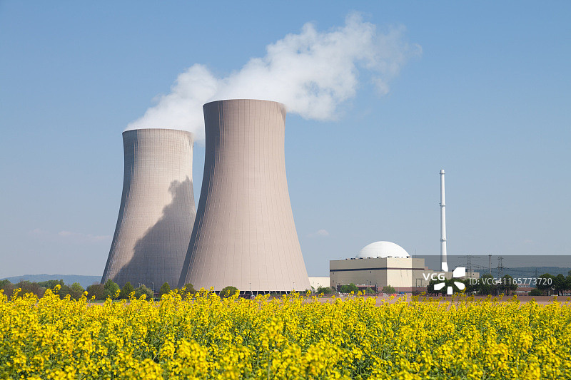 核电站与蒸汽冷却塔和油菜田图片素材