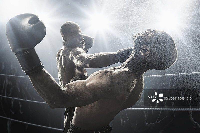 在拳击台上击打对手的非裔美国拳击手图片素材