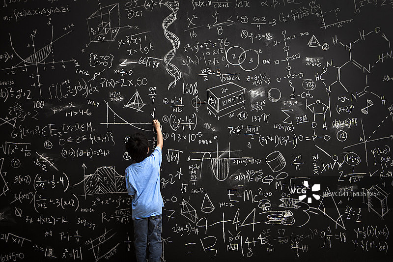 小男孩在黑板上写数学方程图片素材