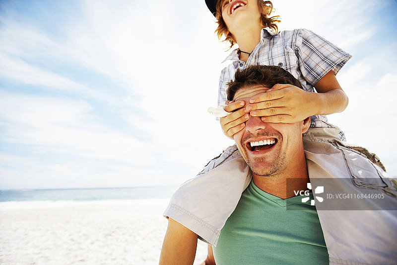 父亲和儿子在海滩上享受图片素材