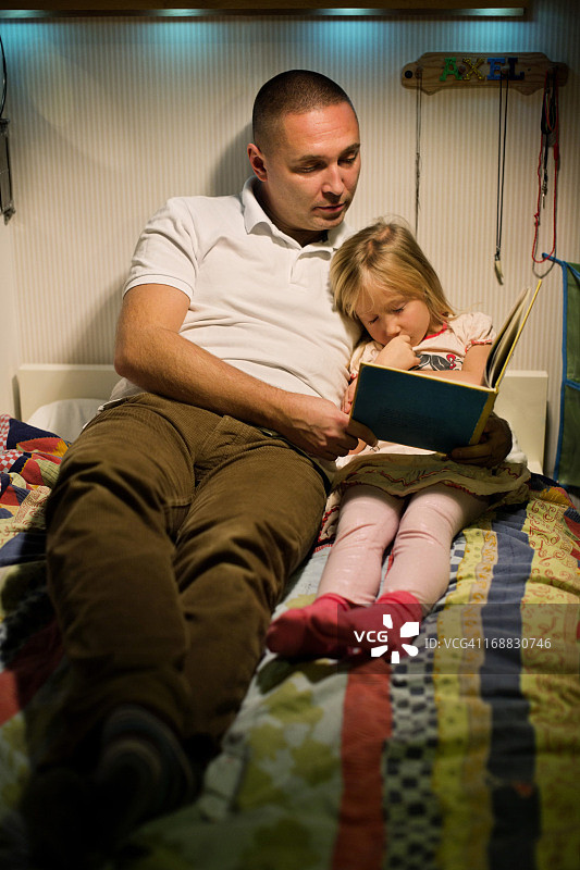 爸爸在看书，女孩睡着了图片素材