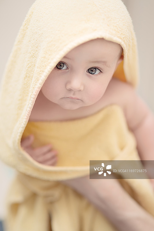 沐浴后用毛巾包裹的婴儿图片素材