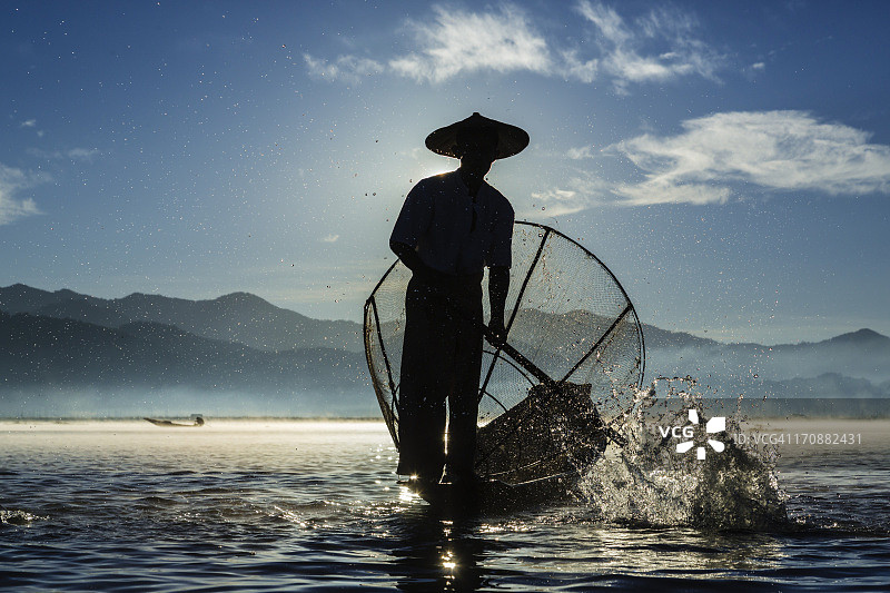 渔夫在水上划着独木舟图片素材