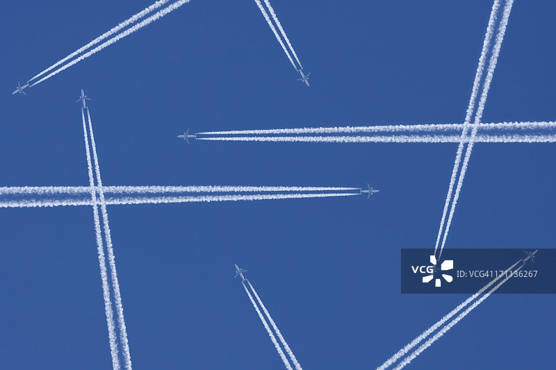 飞机在半空中对着蓝天留下的蒸汽痕迹图片素材