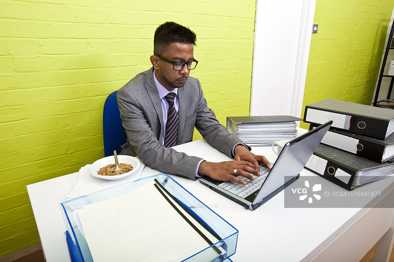 肖像的印度商人在他的笔记本电脑在他的办公桌图片素材