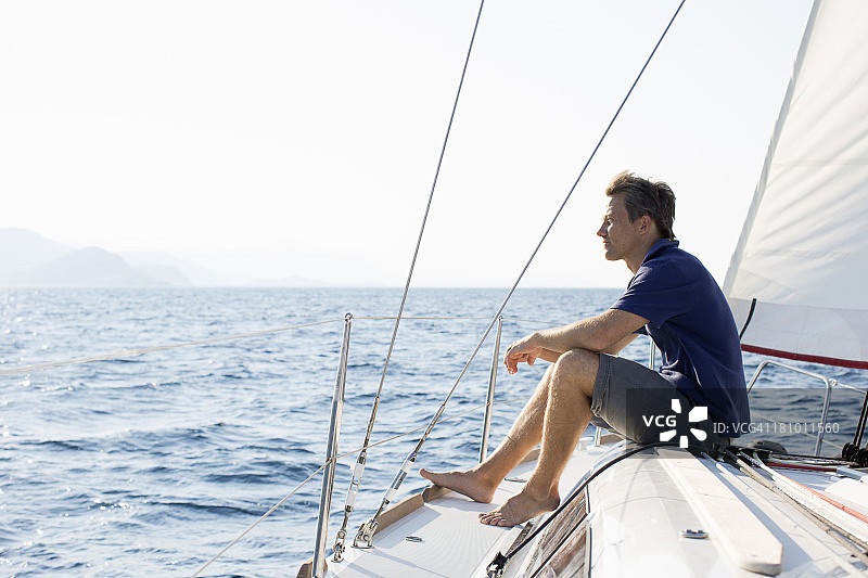 一名男子坐在帆船船头图片素材