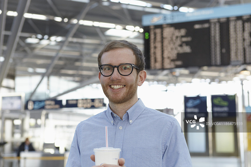 德国，科隆，中年男子在机场拿着饮料图片素材