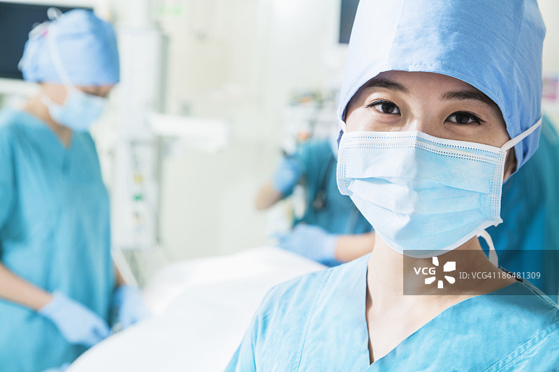 女外科医生戴着外科口罩在手术室的肖像，特写图片素材