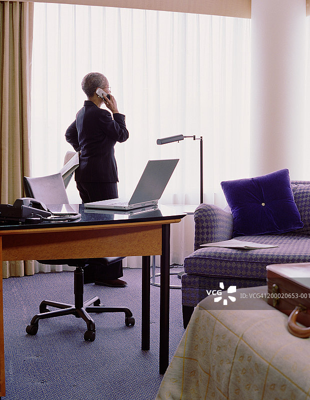 成熟的女商人在酒店房间打电话图片素材